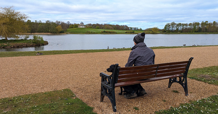 man sitting on bench with dog admiring the view of Hardwick Park, Sedgefield, County Durham
